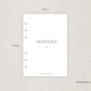 Pode incluir: Uma folha de planeamento branca com a palavra "MONTHLY" impressa numa fonte minimalista. A folha tem 17,1 cm de largura e 12,1 cm de altura, com furos pr&eacute;-perfurados para um fich&aacute;rio. O ano "2024" est&aacute; impresso abaixo de "MONTHLY".