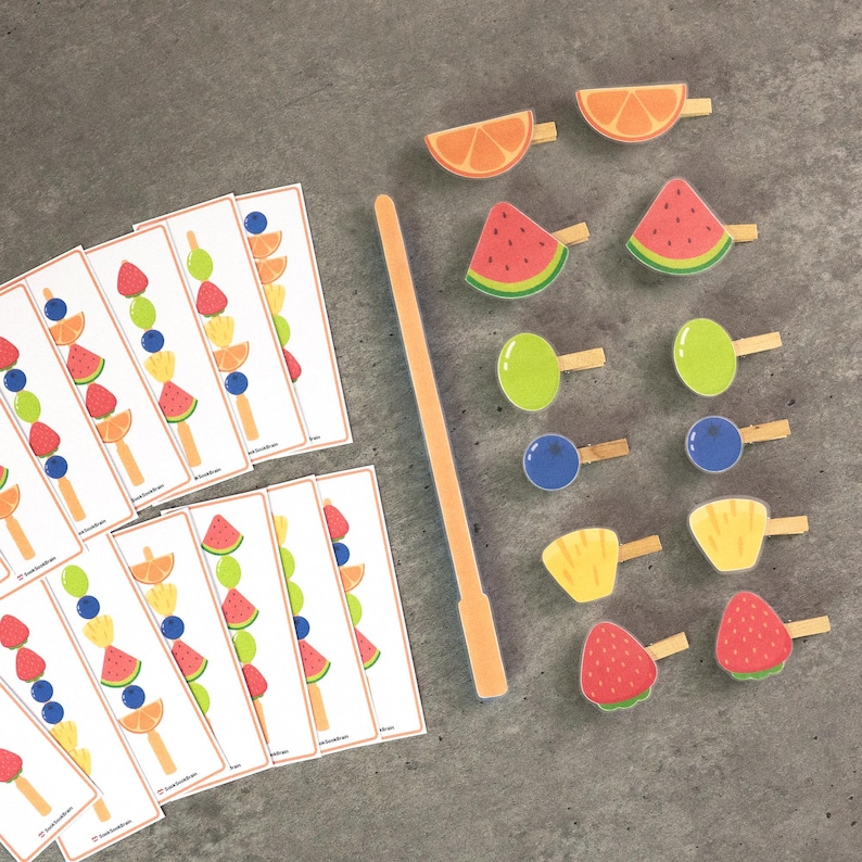 Peut inclure: Un jeu &eacute;ducatif color&eacute; avec des pi&egrave;ces en bois en forme de fruits et des cartes assorties. Les pi&egrave;ces en bois comprennent des tranches d'orange, de past&egrave;que, de raisins, de myrtilles, d'ananas et de fraises. Les cartes affichent des combinaisons de fruits sur des b&acirc;tonnets de glace.