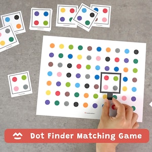 May include: A dot finder matching game consisting of a large white sheet printed with a grid of multicolored dots and several smaller square cards featuring four dots each. A black square frame is used to isolate specific dot patterns on the sheet.