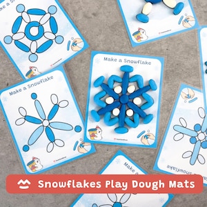 Op de afbeelding: Klei-matten met sneeuwvlokontwerpen. De matten zijn wit met blauwe sneeuwvlokcontouren en de tekst "Make a Snowflake". Blauwe en witte klei wordt gebruikt om de sneeuwvlokken te maken. De afbeelding bevat ook een rode banner met de tekst "Snowflakes Play Dough Mats".