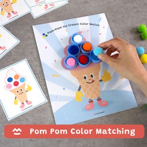May include: A color matching game with an ice cream cone theme. The game includes a printed sheet with an ice cream cone illustration, blue cups, and colorful pom-poms. The text "Pom Pom Color Matching" is displayed on the bottom of the image.
