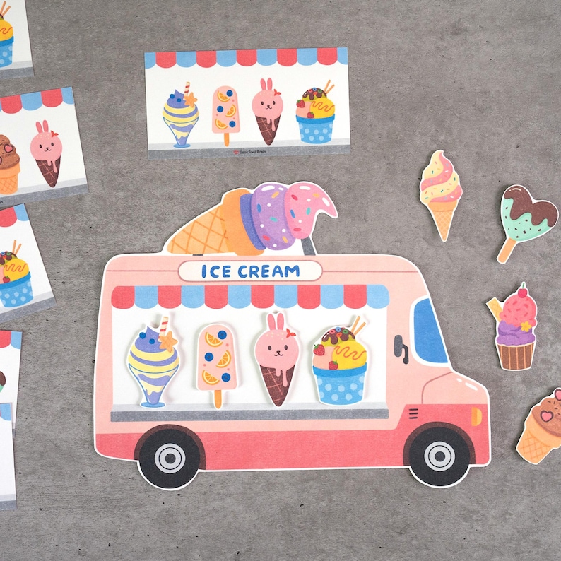 May include: A die-cut paper ice cream truck in light pink and red with a blue and red striped awning and the text ICE CREAM. The truck features illustrations of various frozen treats including a bunny-shaped cone and a blue cup with sprinkles.