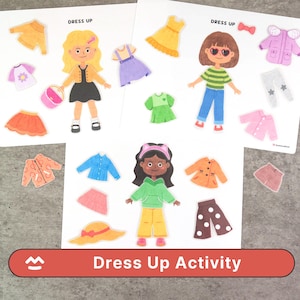 Puede incluir: Un conjunto de "Dress Up Activity" con muñecas de papel y ropa. El conjunto incluye muñecas de papel con diferentes tonos de piel y peinados, además de vestidos, faldas, chaquetas y accesorios de varios colores. El texto "Dress Up Activity" es visible.