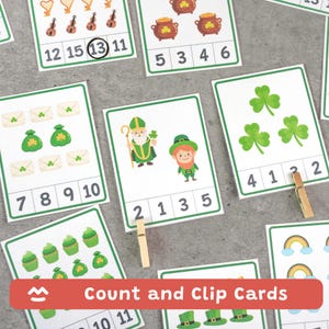 May include: Count and Clip Cards featuring St. Patrick's Day themes. The cards have images of shamrocks, leprechauns, and pots of gold. Numbers are displayed on the cards for counting practice. A wooden clothespin is included for clipping.