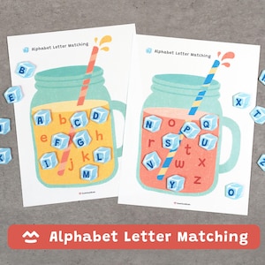 May include: Two educational alphabet letter matching game cards. Each card features a mason jar design with ice cubes containing letters. The cards have a straw and the text "Alphabet Letter Matching".