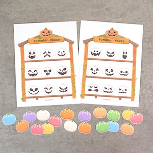 May include: Two white paper sheets featuring a wooden shelf illustration labeled Pumpkin House, each with nine empty pumpkin outlines. Below the sheets are twenty-two small, colorful, die-cut pumpkin shapes in shades of orange, pink, yellow, green, blue, purple, and white.