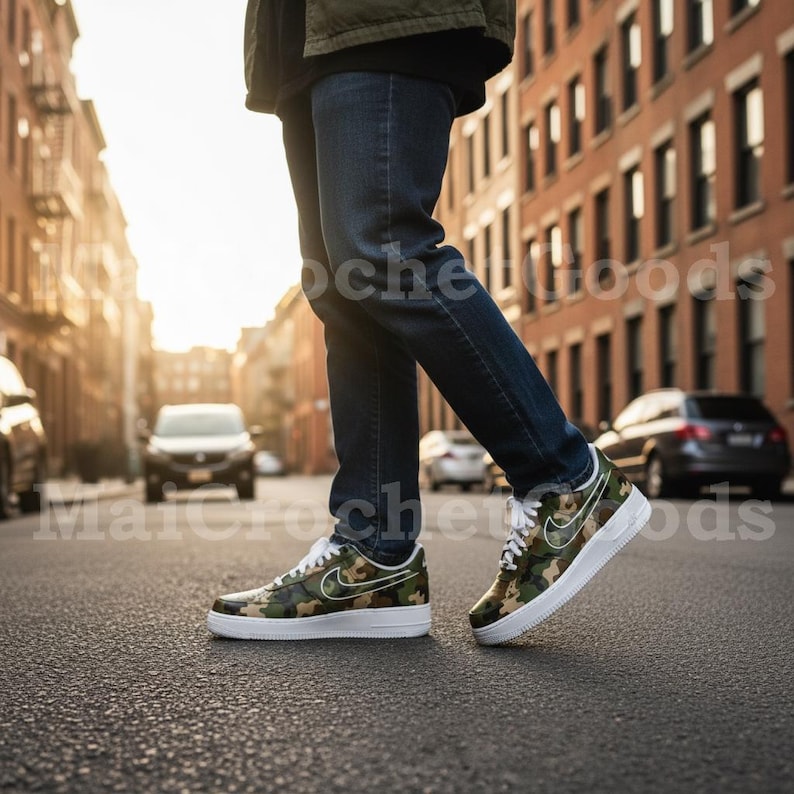 May include: Camouflage-patterned sneakers with white soles and laces. The sneakers feature a white Nike swoosh logo on the side. The shoes are worn with blue jeans. The image is taken on a city street.