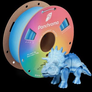 May include: A blue and white triceratops dinosaur figurine stands next to a spool of blue filament. The spool has the text "Panchroma YOUR FILAMENT PALETTE" and "Net weight: 1kg Spool weight: ~145g". The dinosaur is a 3D print.