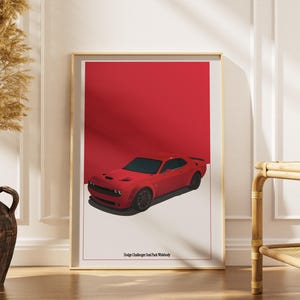 Puede incluir: Una impresión enmarcada con un coche Dodge Challenger SRT Hellcat Widebody rojo. El coche está sobre un fondo rojo con una base blanca. La impresión está en un marco dorado y se muestra contra una pared blanca.