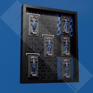 Peut inclure: Tableau encadré avec six petites voitures de course bleues et des détails rouges. Les voitures sont montées sur des plateformes noires dans un cadre noir, avec un fond à motifs et des touches de bleu. Dimensions: environ 50 cm x 40 cm.