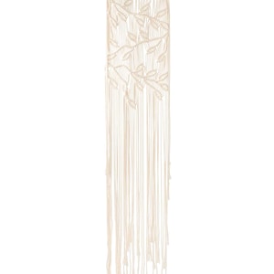 Puede incluir: Un tapiz de macramé blanco con un diseño de hojas. El tapiz está hecho de cordón de algodón y tiene una varilla de madera en la parte superior.