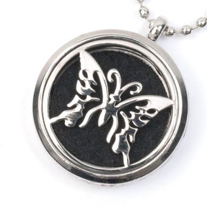 May include: Silver pendant necklace with a butterfly design. The pendant has a black felt insert and a silver chain.