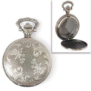 May include: A silver pocket watch with an ornate floral design on the front. The watch has a hinged lid and a chain attached to the top.
