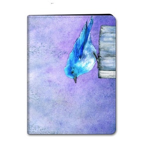 Peut inclure: Une peinture à l'aquarelle d'un oiseau bleu perché sur un poteau en bois sur un fond d'aquarelle violet et bleu.