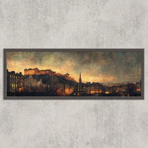 May include: A framed panoramic print of Edinburgh, Scotland, at dusk. The artwork depicts the city's skyline, including Edinburgh Castle, with warm, golden light illuminating the buildings against a dark, moody sky. The frame is dark brown.