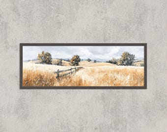 May include: A framed landscape painting depicts a golden field with a wooden fence, trees, and rolling hills under a cloudy sky. The artwork is in a rectangular, dark brown frame.