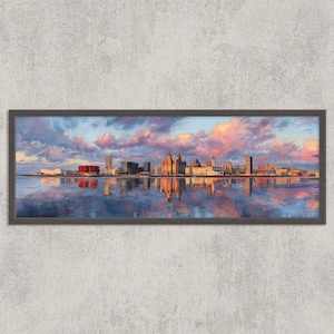 Peut inclure: Peinture panoramique encadrée d'une ligne d'horizon urbaine se reflétant dans l'eau calme. L'œuvre présente des bâtiments bruns, rouges et gris sous un ciel de nuages roses, oranges et bleus. Le cadre est gris foncé.