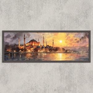 Op de afbeelding: Een ingelijste panoramische prent van een stadsgezicht bij zonsondergang. Het kunstwerk toont een groot gebouw met minaretten en koepels, weerspiegeld in het water. De lucht gaat over van donkere wolken naar levendig oranje en geel.