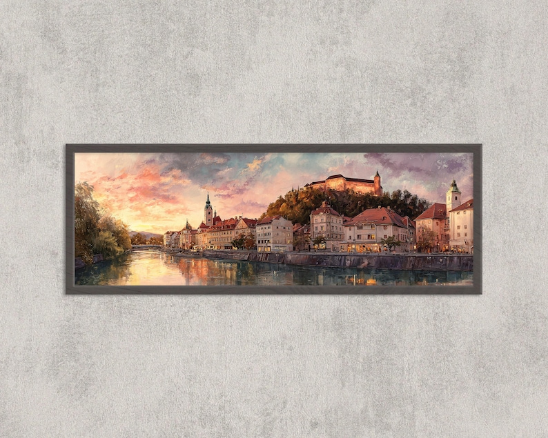 May include: A framed panoramic painting of a European city at sunset. The artwork depicts buildings along a river, with a castle on a hill. The sky is filled with pink, orange, and purple hues, reflecting in the water.