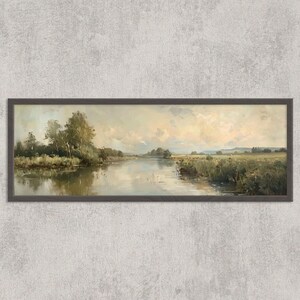 Könnte beinhalten: Gerahmtes Landschaftsgemälde, das eine ruhige Flussszene darstellt. Das Kunstwerk verwendet eine gedämpfte Farbpalette mit Grüntönen, Braun und Beige. Bäume säumen die Ufer, und der Himmel ist mit weichen Wolken gefüllt. Das Gemälde ist in einem dunkelbraunen Rahmen eingefasst.