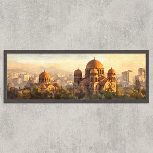 May include: A framed print of a cityscape featuring a large cathedral with multiple domes. The artwork has a warm color palette with shades of orange, yellow, and brown, suggesting a sunset or sunrise. The print is rectangular and framed in a dark color.