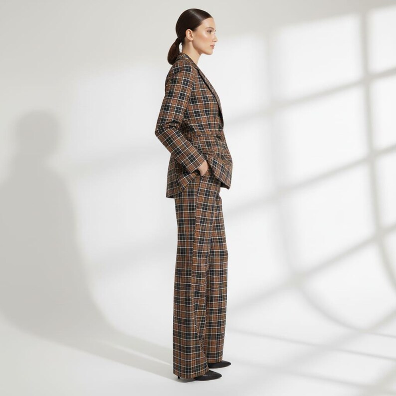 May include: A brown, black, and white plaid suit, including a blazer and wide-leg pants. The blazer has a notched lapel and a two-button closure. The pants are high-waisted. The suit is made of a woven fabric.
