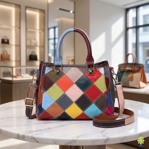 Puede incluir: Un bolso de mano multicolor con un patrón de rombos en tonos rojo, azul, amarillo, verde, rosa y marrón. El bolso cuenta con dos asas superiores, una de color azul claro y otra de color rojo oscuro, además de una correa ajustable extraíble.