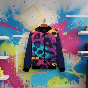 May include: A vibrant bomber jacket with a colorful leopard print design in shades of purple, blue, yellow, and pink. The jacket has navy blue sleeves and a black collar and cuffs. It is hanging on a wall with colorful paint splatters.
