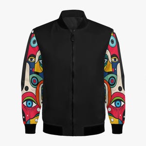 Puede incluir: Chaqueta bomber negra con arte de caras abstractas coloridas en las mangas. La chaqueta tiene una cremallera negra y puños y dobladillo negros de canalé. Las mangas presentan un diseño vibrante con ojos y formas geométricas.