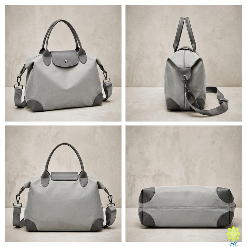 Puede incluir: Una bolsa de viaje gris claro con una correa para el hombro a juego y detalles en gris oscuro en las esquinas, el asa y la solapa. La bolsa tiene forma rectangular con un asa superior y una correa para el hombro desmontable. La bolsa est&aacute; hecha de un material duradero.