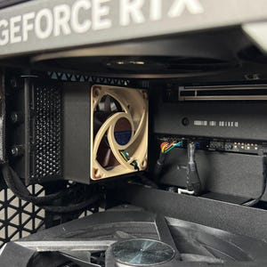 May include: Close-up view of a computer's interior, showing a black and silver graphics card with a fan. The card has the text "GEFORCE RTX" printed on it.