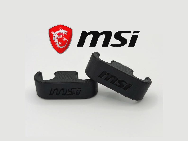 May include: Two black, curved brackets with the MSI logo imprinted on them. The MSI logo is also displayed above the brackets, featuring a red shield with a white dragon and the letters "msi" in black.