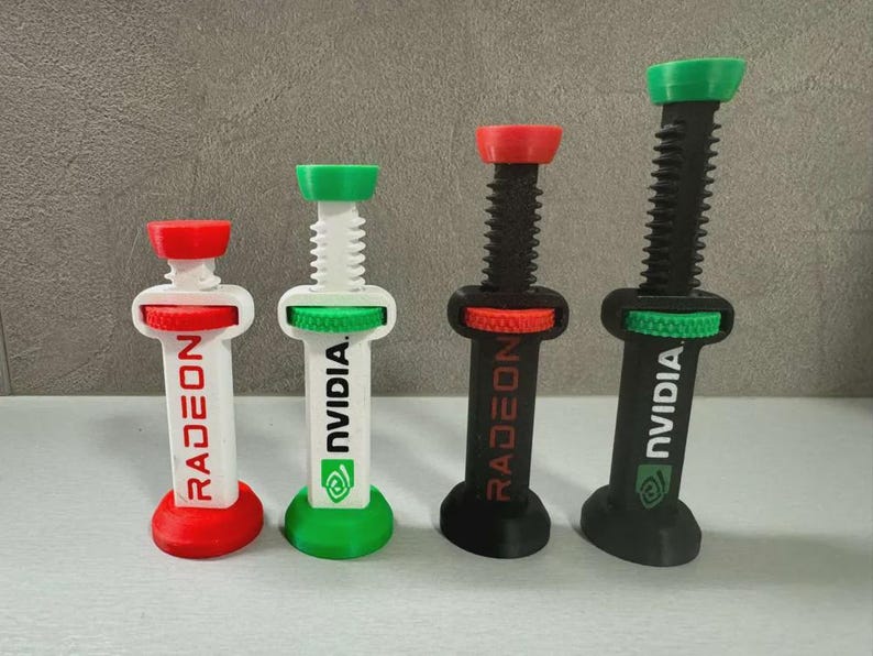 Pode incluir: Quatro objetos impressos em 3D em forma de seringa, com elementos vermelhos, verdes, pretos e brancos. Dois t&ecirc;m "RADEON" e dois "NVIDIA". Os objetos t&ecirc;m um design de parafuso e s&atilde;o provavelmente decorativos ou de novidade.