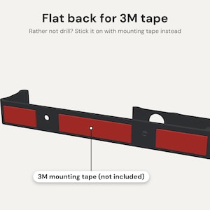 May include: A black, elongated mounting bracket with a flat back featuring three rectangular red adhesive strips. The text reads: Flat back for 3M tape, Rather not drill? Stick it on with mounting tape instead, and 3M mounting tape (not included).