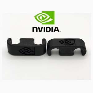 May include: Two black 3D-printed brackets featuring the NVIDIA logo. The brackets have a curved design with a rectangular central section. The NVIDIA logo is visible on each bracket. The background is white, with the NVIDIA logo and text at the top.