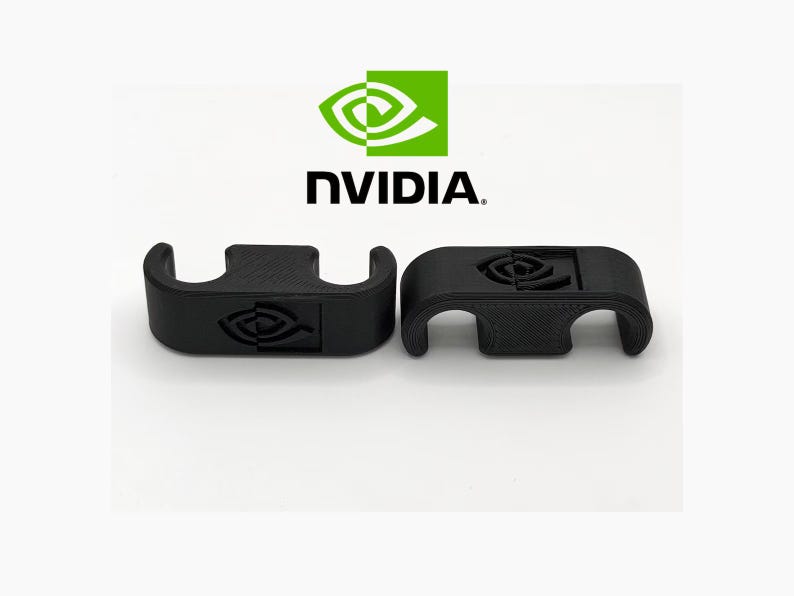 May include: Two black 3D-printed brackets featuring the NVIDIA logo. The brackets have a curved design with a rectangular central section. The NVIDIA logo is visible on each bracket. The background is white, with the NVIDIA logo and text at the top.