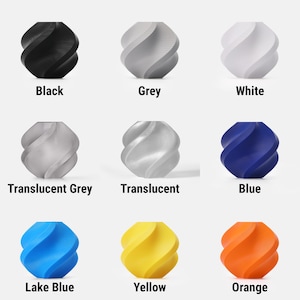 Puede incluir: Nueve objetos decorativos en espiral de varios colores: negro, gris, blanco, gris transl&uacute;cido, transl&uacute;cido, azul, azul lago, amarillo y naranja. Cada objeto tiene un dise&ntilde;o texturizado &uacute;nico y est&aacute; etiquetado con su color.