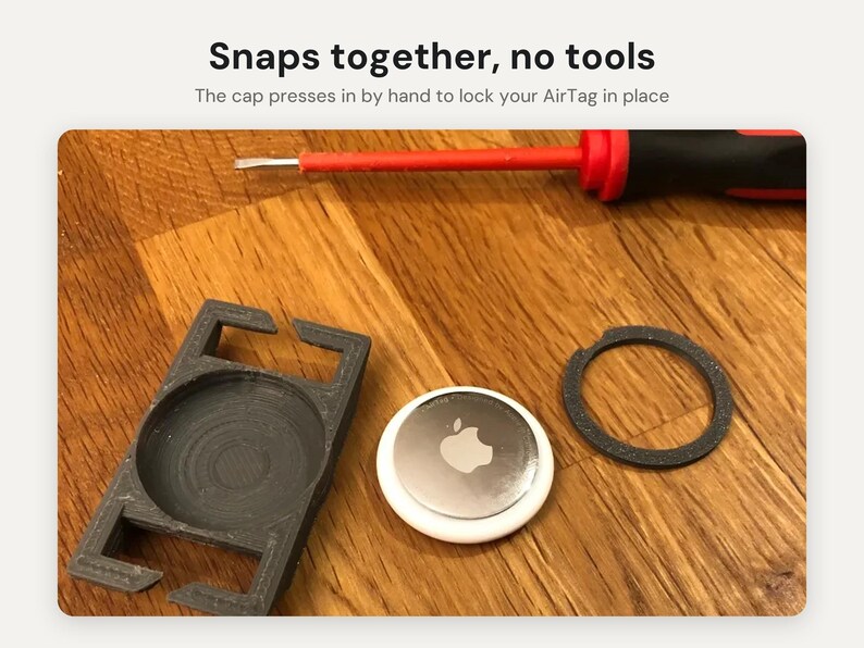 May include: A black plastic AirTag holder with a separate circular cap and a silver Apple AirTag. The text Snaps together, no tools and The cap presses in by hand to lock your AirTag in place is visible above a red and black screwdriver.