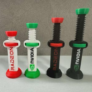 Pode incluir: Quatro objetos impressos em 3D em forma de seringa. Dois s&atilde;o brancos com detalhes vermelhos e verdes, com os r&oacute;tulos "RADEON" e "NVIDIA". Os outros dois s&atilde;o pretos com detalhes vermelhos e verdes, tamb&eacute;m com os r&oacute;tulos "RADEON" e "NVIDIA".