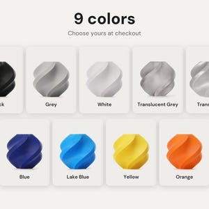 May include: A collection of nine small, spiraled, geometric objects displayed in individual white squares. The colors include black, grey, white, translucent grey, translucent, blue, lake blue, yellow, and orange. Text reads 9 colors.