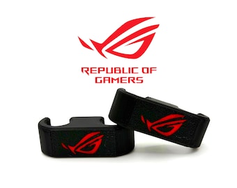 May include: Two black gaming accessories with a red logo, featuring the text "REPUBLIC OF GAMERS" above. The logo is a stylized red design. The accessories are on a white background.