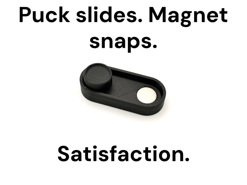 May include: A black, rectangular fidget toy with a circular puck and a silver magnet. The text "Puck slides. Magnet snaps. Satisfaction." is displayed above and below the toy on a white background.
