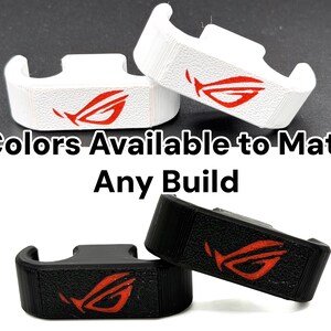 May include: Two gaming accessories in white and black, each with a red logo. The text "2 Colors Available to Match Any Build" is visible. These accessories are designed to complement various gaming setups.