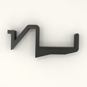 Op de afbeelding: Een zwart, geometrisch 3D-geprint object met een unieke vorm. Het ontwerp bestaat uit een reeks verbonden, hoekige lijnen en een kleine, verticale verlenging. Het object staat tegen een effen witte achtergrond.