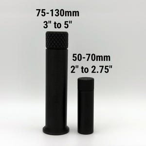 Puede incluir: Dos objetos cil&iacute;ndricos negros con tapas texturizadas sobre fondo blanco. El m&aacute;s alto mide 75-130mm, y el m&aacute;s bajo 50-70mm de altura. La imagen incluye texto con las medidas en pulgadas y mil&iacute;metros.