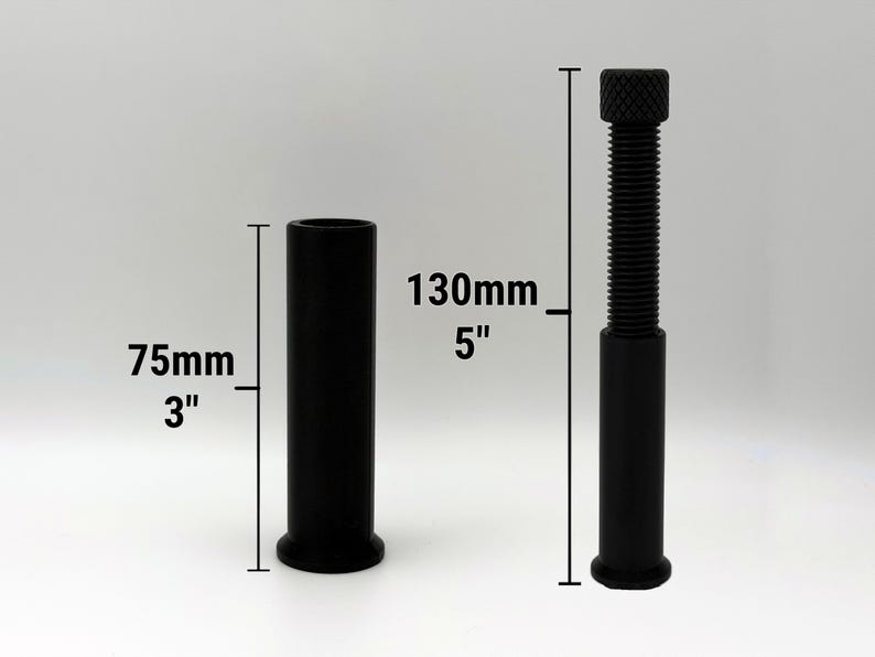 Puede incluir: Se muestran dos objetos cil&iacute;ndricos negros sobre un fondo blanco. Uno mide 75 mm de alto, el otro 130 mm de alto y tiene una parte superior roscada. Ambos se utilizan para ajustar la altura.