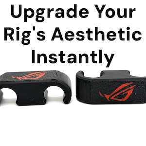 May include: Two black cable organisers with a textured surface and a red logo. The text "Upgrade Your Rig's Aesthetic Instantly" is printed above the organisers. The organisers have a unique design.