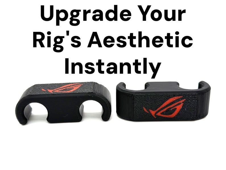 May include: Two black cable organisers with a textured surface and a red logo. The text "Upgrade Your Rig's Aesthetic Instantly" is printed above the organisers. The organisers have a unique design.