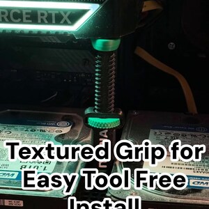 Pode incluir: Uma imagem em close-up de um componente de computador com uma pega texturizada iluminada em verde. O texto "TEXTURED GRIP FOR EASY TOOL FREE INSTALL" &eacute; exibido em branco. O componente est&aacute; instalado perto de discos r&iacute;gidos.