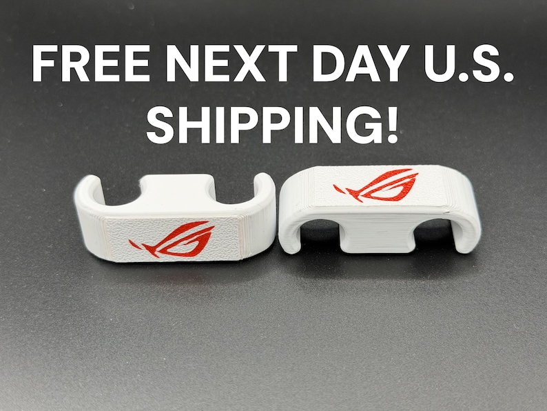 May include: Two white, curved plastic components with a red logo. The components have a rectangular top with a curved base and are set against a dark background. The logo is a stylized red design.